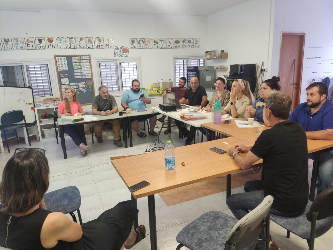 המשתתפים בהכשרה יושבים בכיתת לימוד מסביב לשולחנות בצורה ח