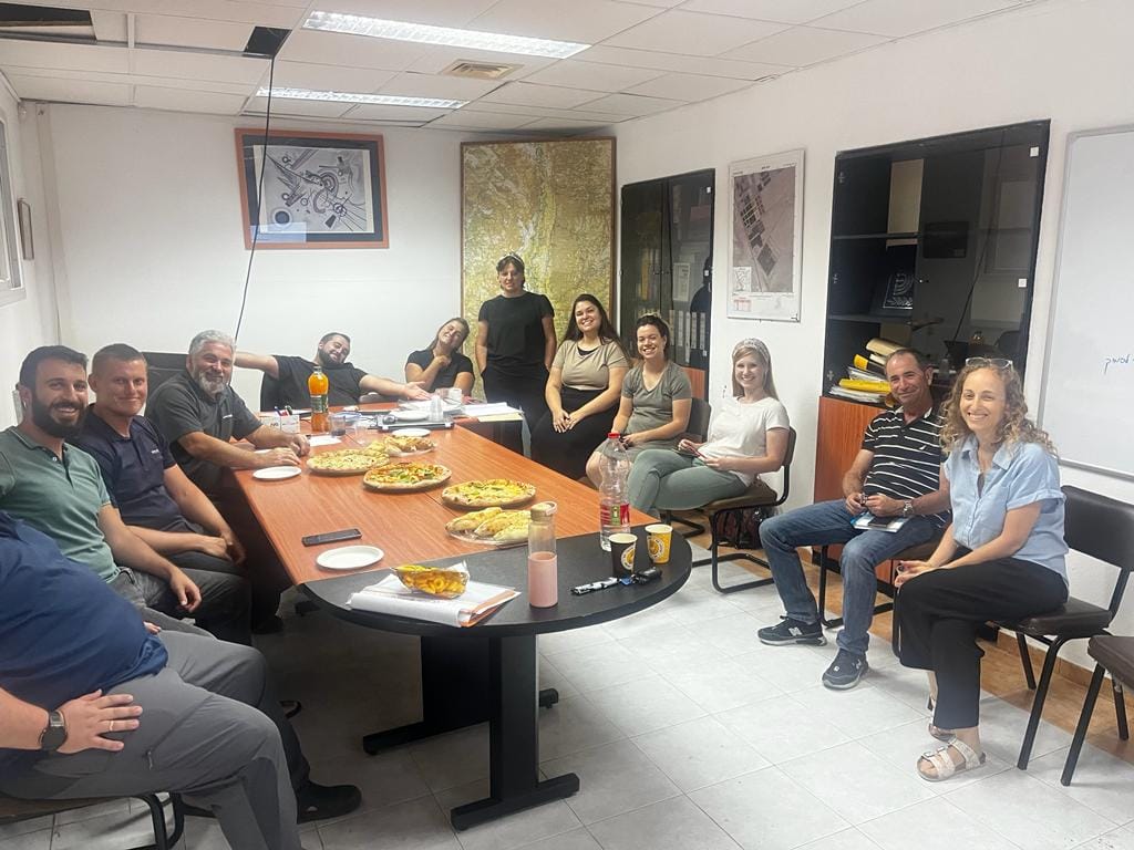 משתתפים בהכשרה יושבים מסביב לשולחן עם כיבוד 